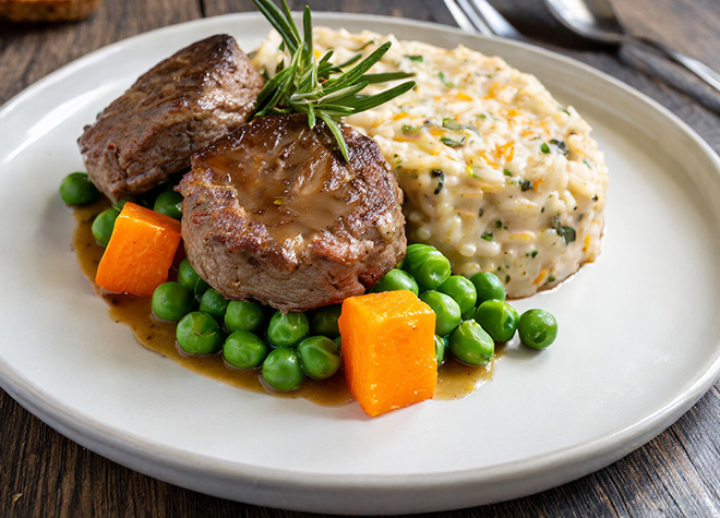 Sautierte Rindsplätzchen an Rosmarinjus & Eblyrisotto mit Erbsen und Karotten