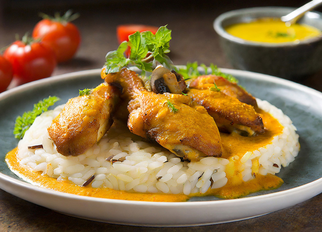 Pouletflügeli mit Curry-Sauce und Tomaten-Steinpilzreis