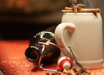 Glühbier in einer Keramiktasse auf einem Tisch vor verschwommenem Hintergrund