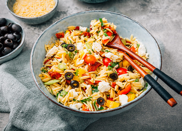 bunter Nudelsalat mit Käse, Oliven und Tomaten.