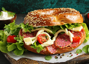 Laugenbrot gefüllt mit Salami, Salat und Tomaten.